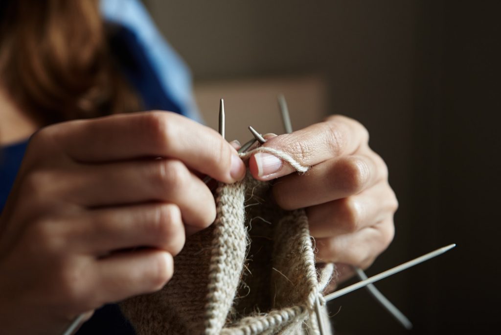 Woman knitting socks with needles